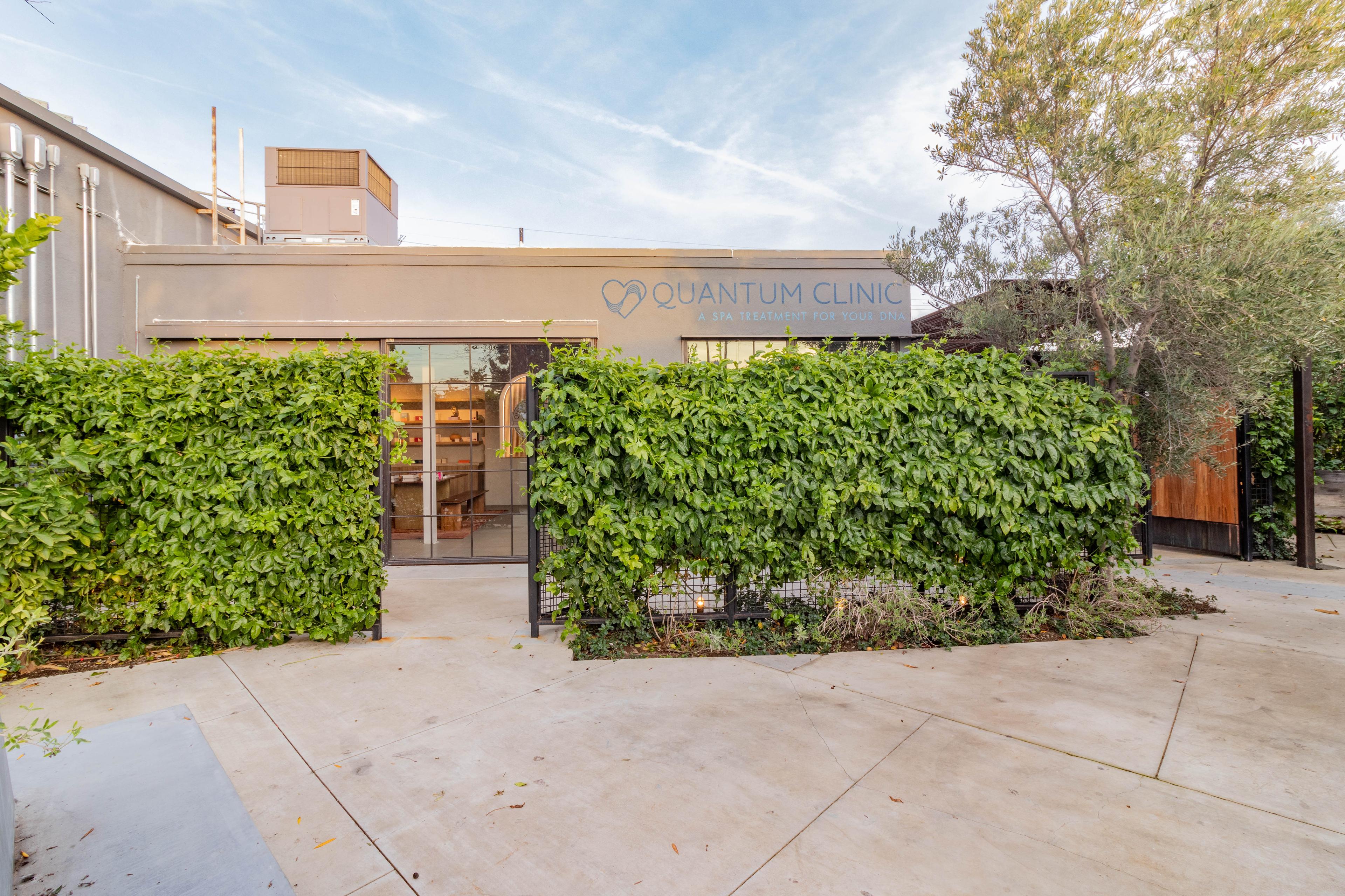 Quantum Clinic entrance with greenery and signage; mission, vision, and values statements highlighting healing through coherence